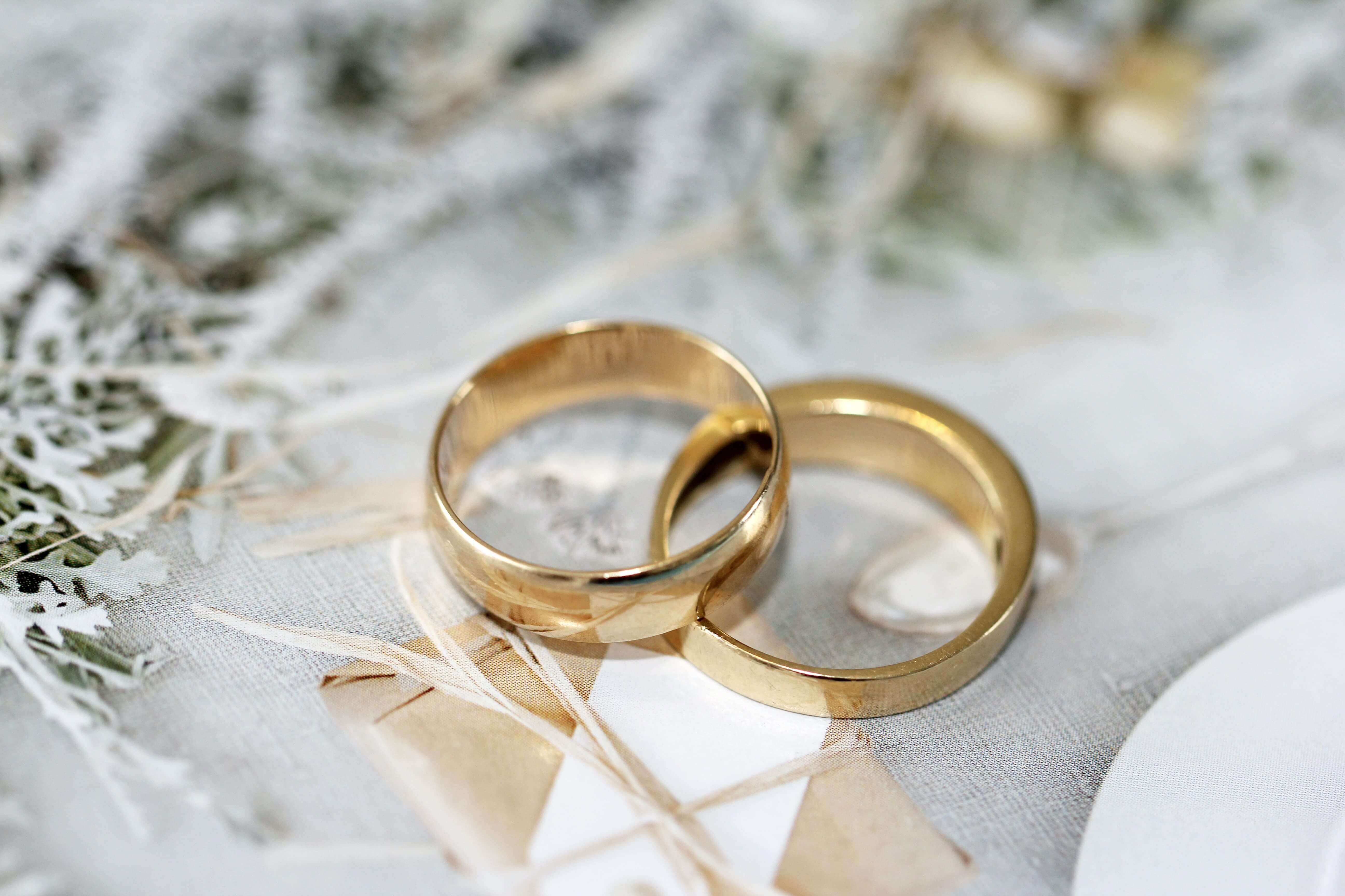 close up of a pair of gold wedding rings with diamonds on a dark  background, selective focus, bokeh. generated ai 24752190 Stock Photo at  Vecteezy